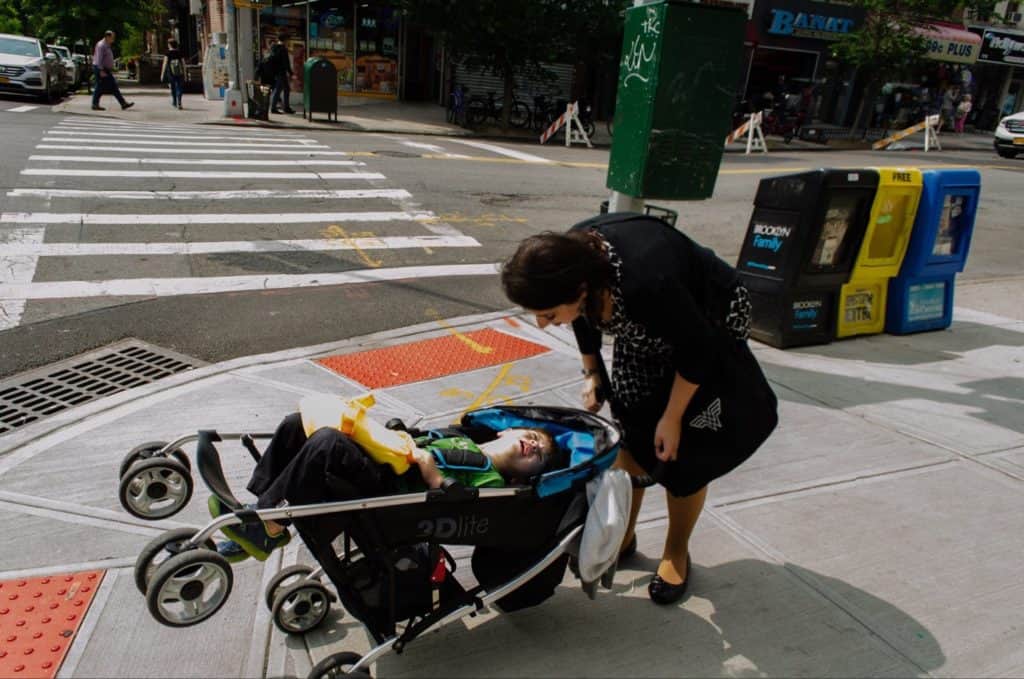 A Mompreneur picking up her son in a stroller at daycare.